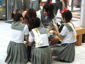A group of Japanese school girls using mobile phones