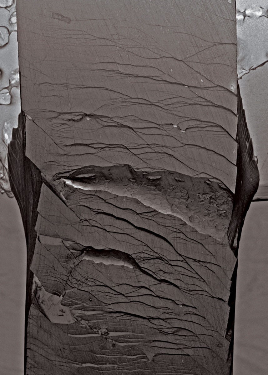 Secondary electron micrographs taken after a bending test on an unnotched Pd79Ag3.5P6Si9.5Ge2 glassy specimen.