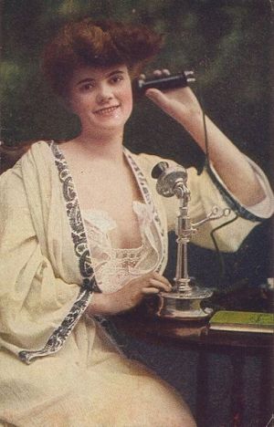 Woman using telephone, c. 1910.