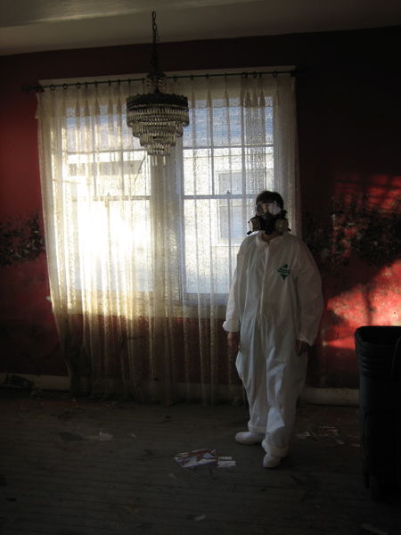 Man in hazard suit next to curtains