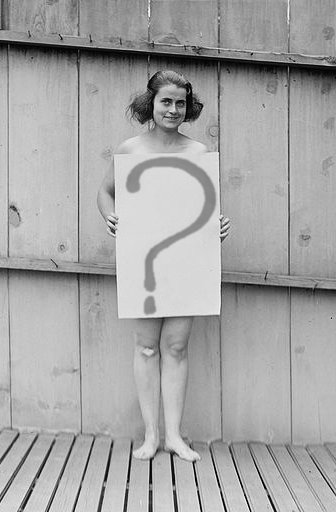 Woman holding sign reading \?\ stands on wooden deck in front of wooden fence. Washington, D.C., 1922.