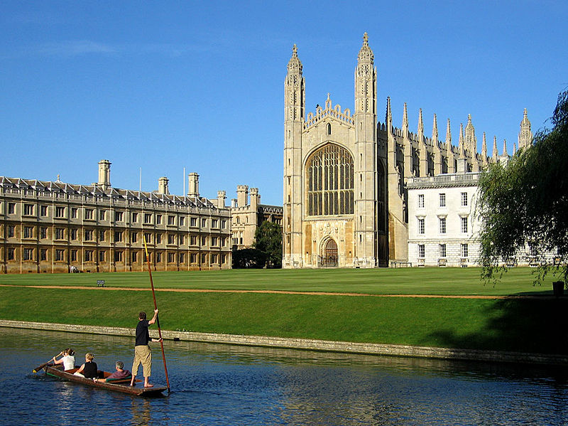 The west end of King's College Chapel seen from The Backs. Clare College Old Court is on the left. A group of people punting along the River Cam can be seen in the foreground.