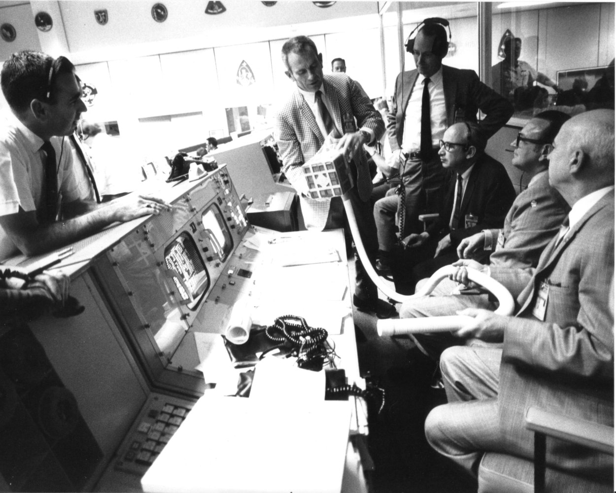  Deke Slayton (check jacket) shows the adapter devised to make use of square Command Module lithium hydroxide canisters to remove excess carbon dioxide from the Apollo 13 LM cabin. As detailed in Lost Moon by Jim Lovell and Jeffrey Kluger, the adapter...