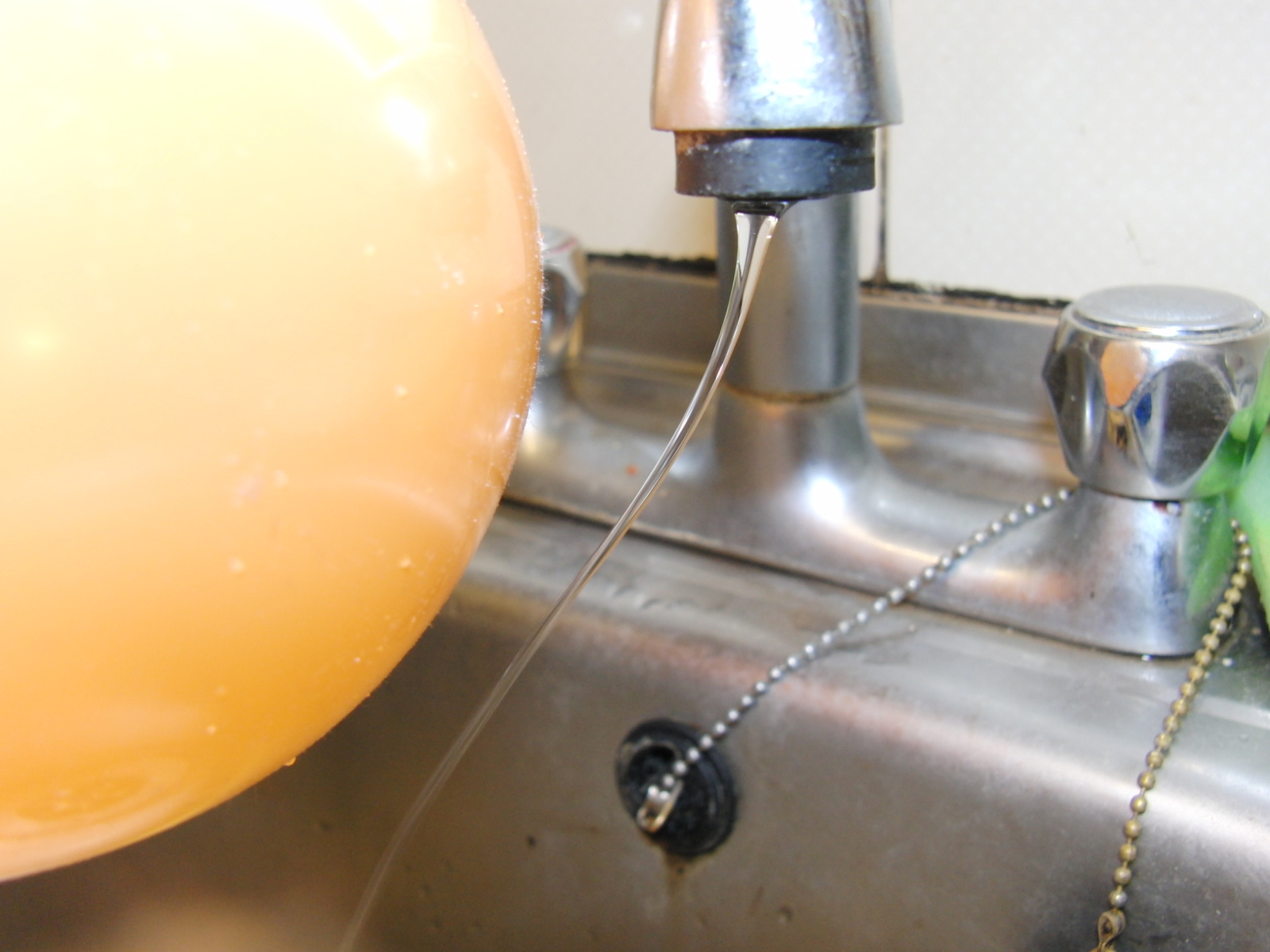 The charged balloon bends the stream of water