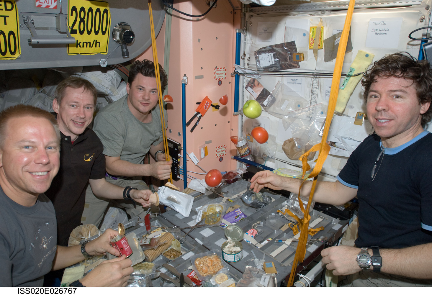  NASA astronaut Tim Kopra (left), European Space Agency astronaut Frank De Winne, cosmonaut Roman Romanenko and NASA astronaut Michael Barratt, all Expedition 20 flight engineers, share a meal at a galley in the Unity node of the International Space...