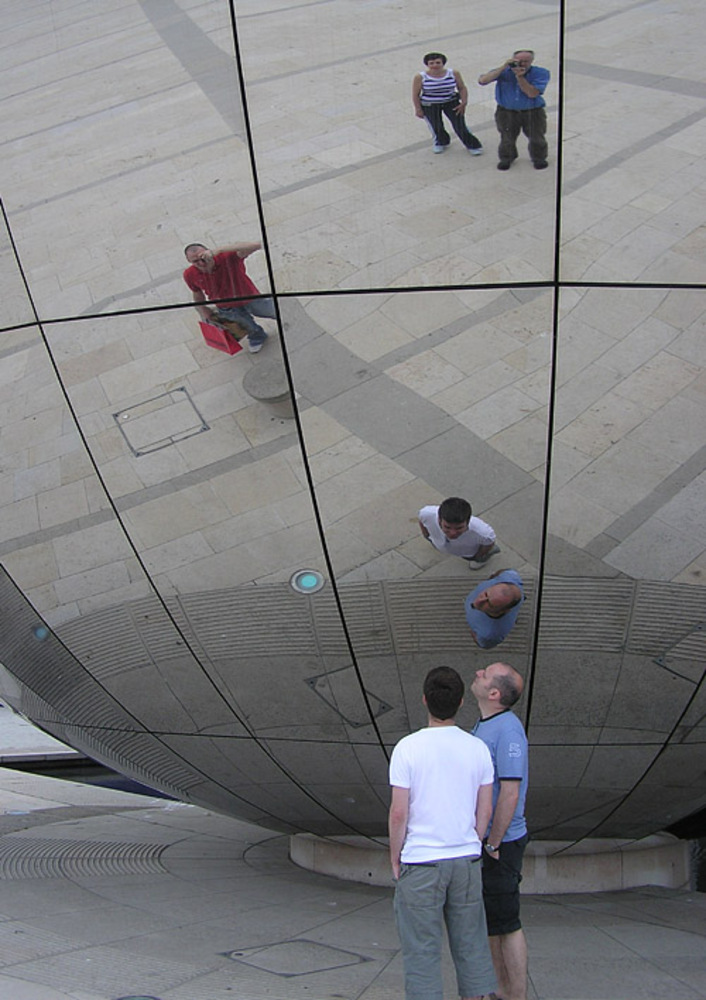 Spherical mirror in Millennium Square, Bristol, England. The photographer is seen top right in the blue shirt. The mirror forms the side of the Explore-At-Bristol Planetarium sphere.