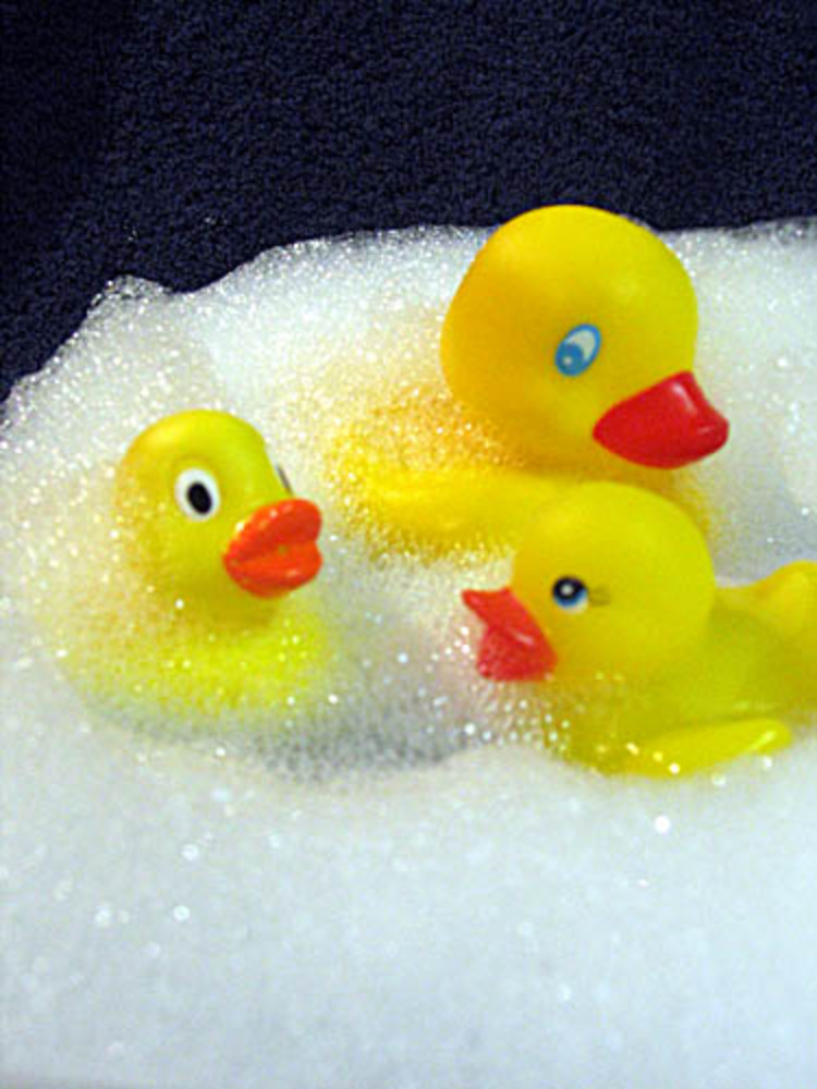 Three yellow rubber ducks play in the bubble bath!