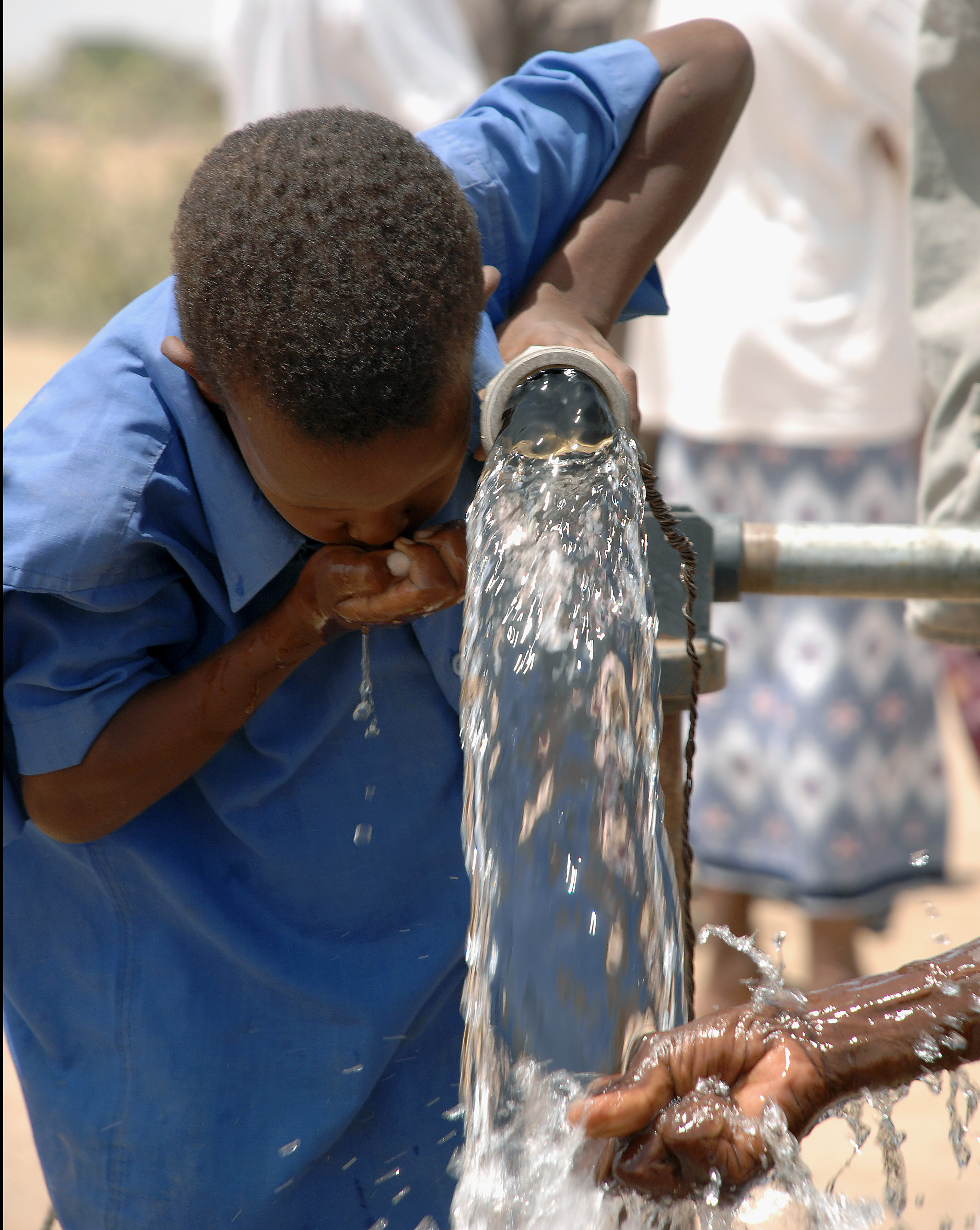 Child drinking from water pump