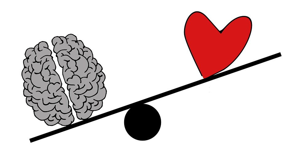 A cartoon brain outweighing a cartoon heart on a balance scale.
