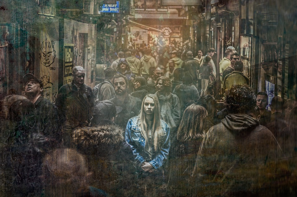 A woman stands in a washed-out, ghostly crowd.