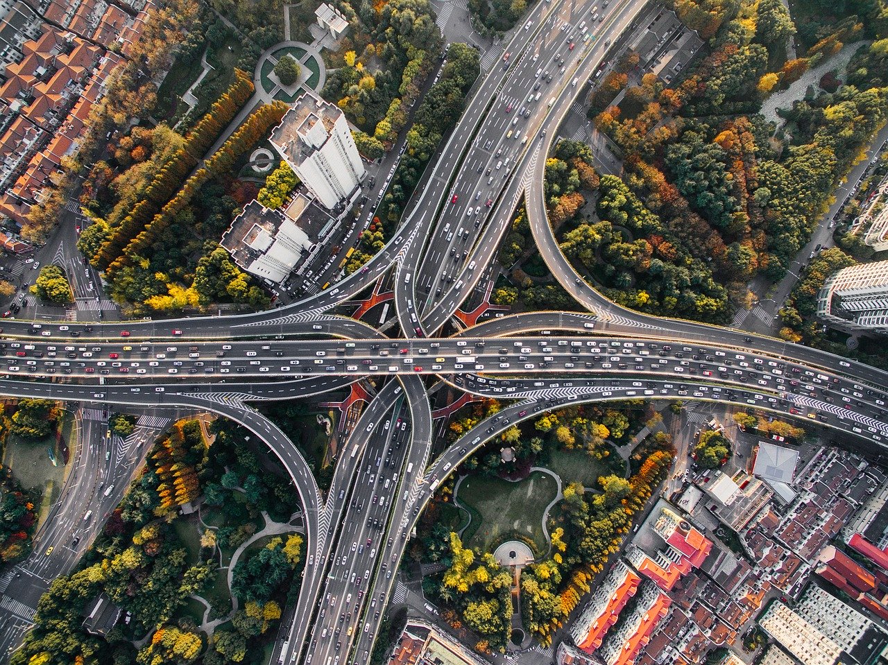 A top down view of a busy junction, surrounded by trees