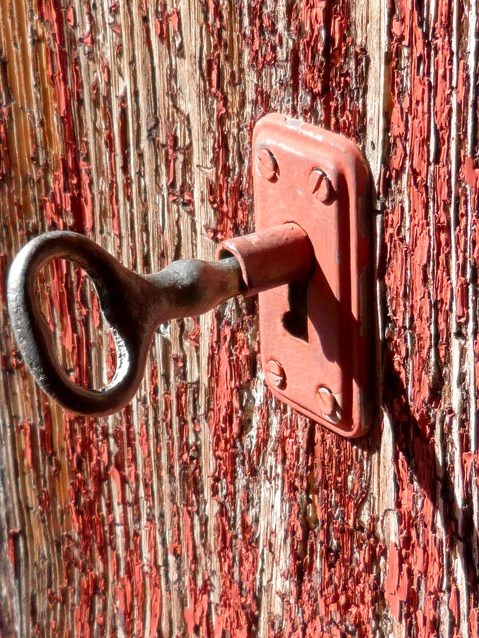 A rustic key partly turned in a lock on a door.