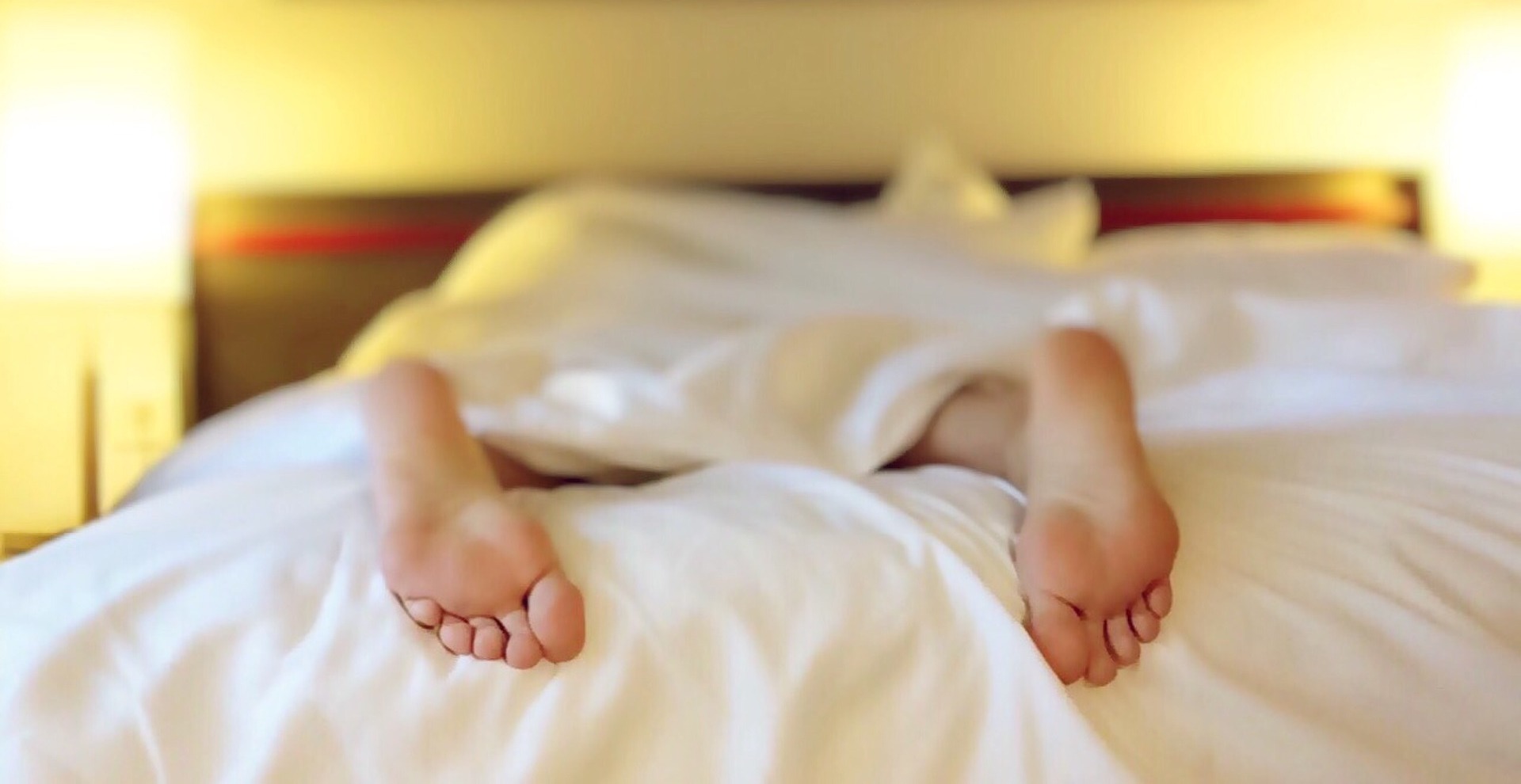 Feet of a sleeping person in bed