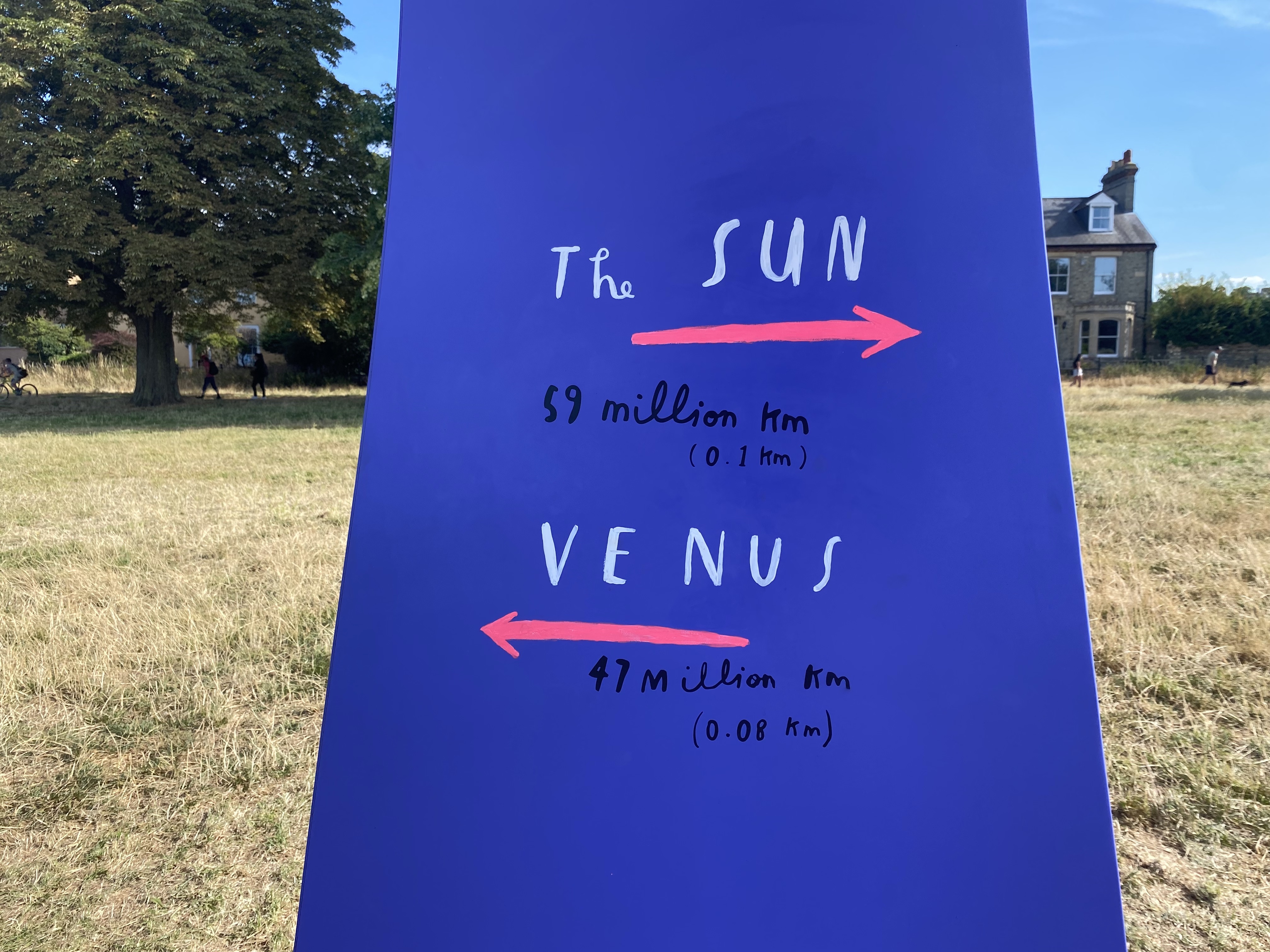 Purple sign saying the distance to the Sun and Venus on the "Our Place in Space" trail