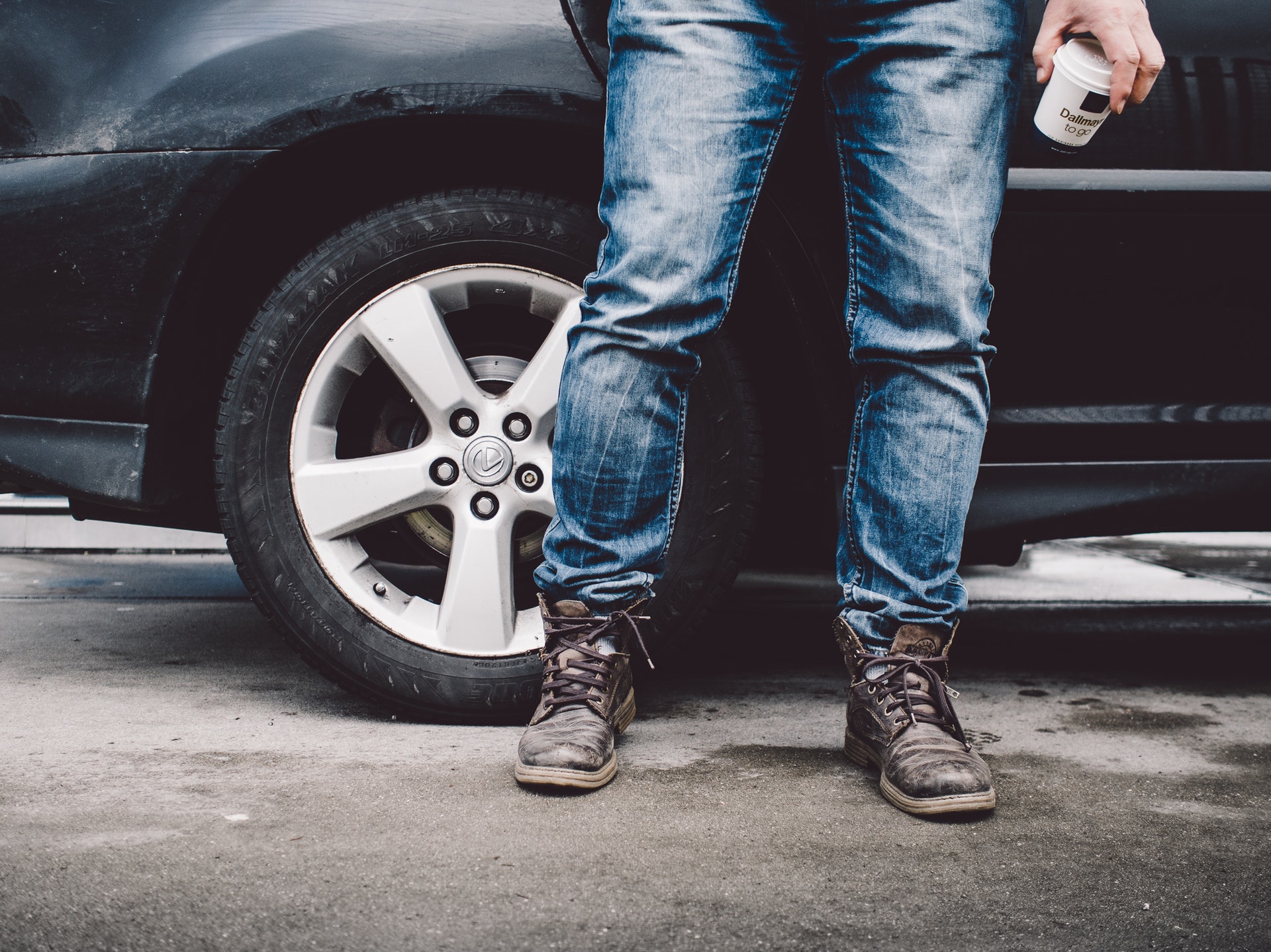 Person wearing jeans standing next to a car