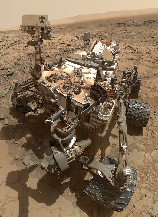 The image shows a robotic rover on the surface of Mars.