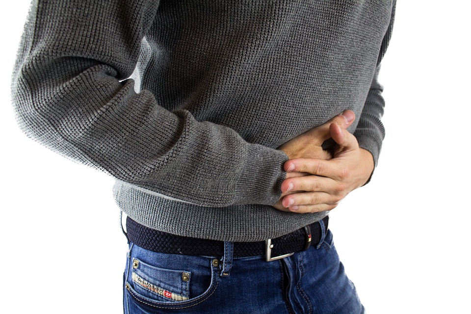 A man gripping his stomach in pain