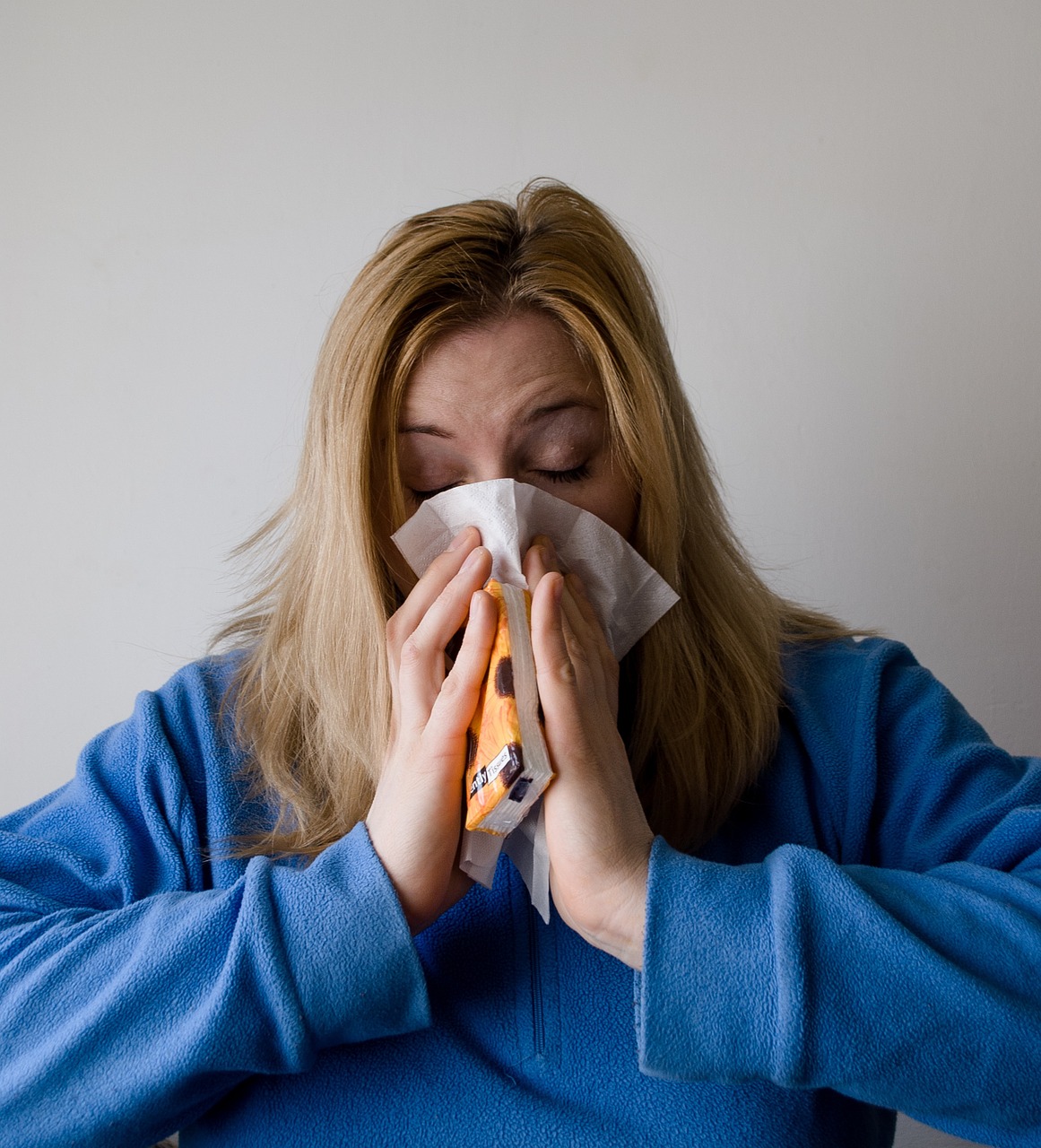 A woman blowing her nose