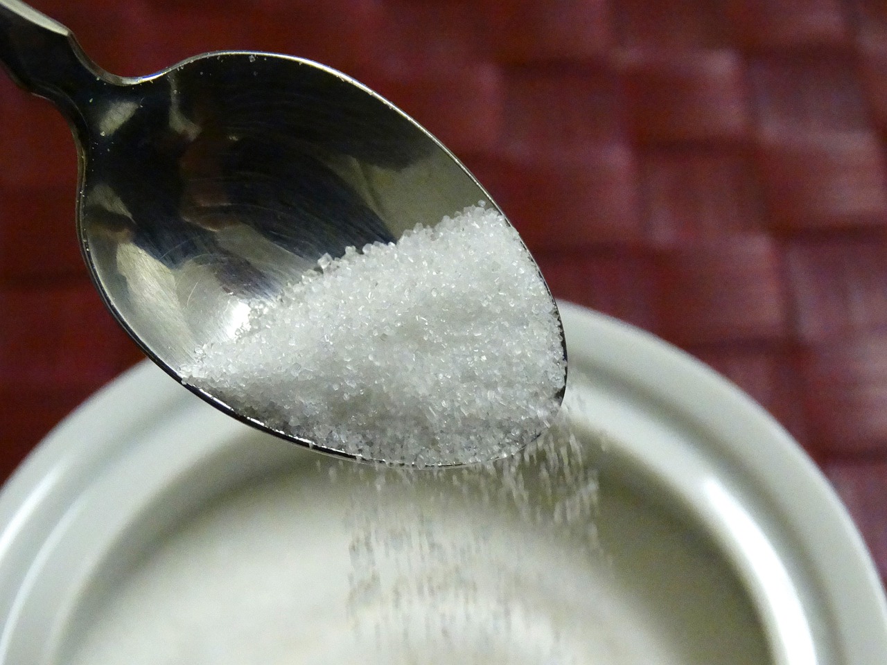 A spoon with white sugar on it