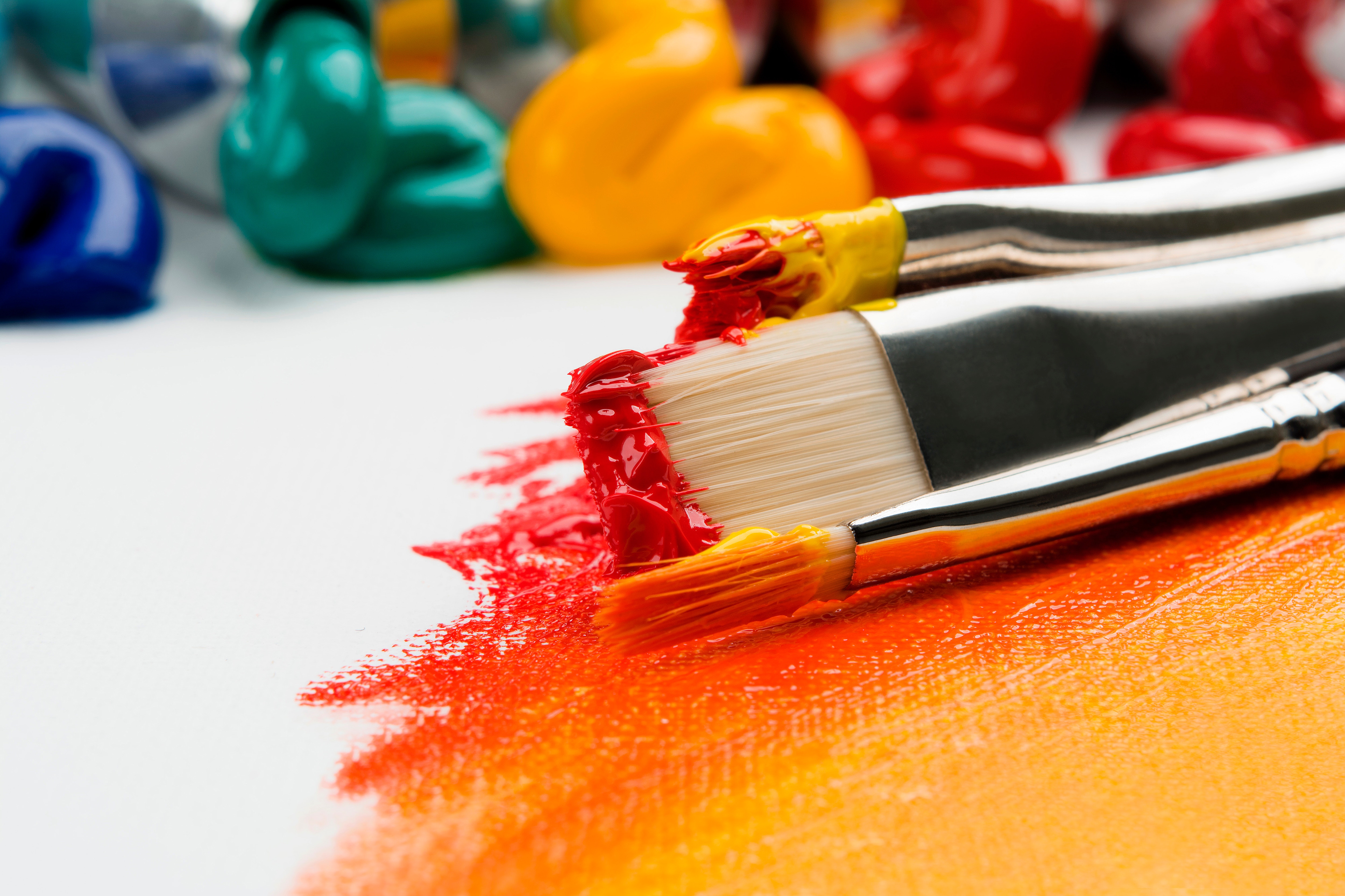 Paintbrushes dipped in yellow and red