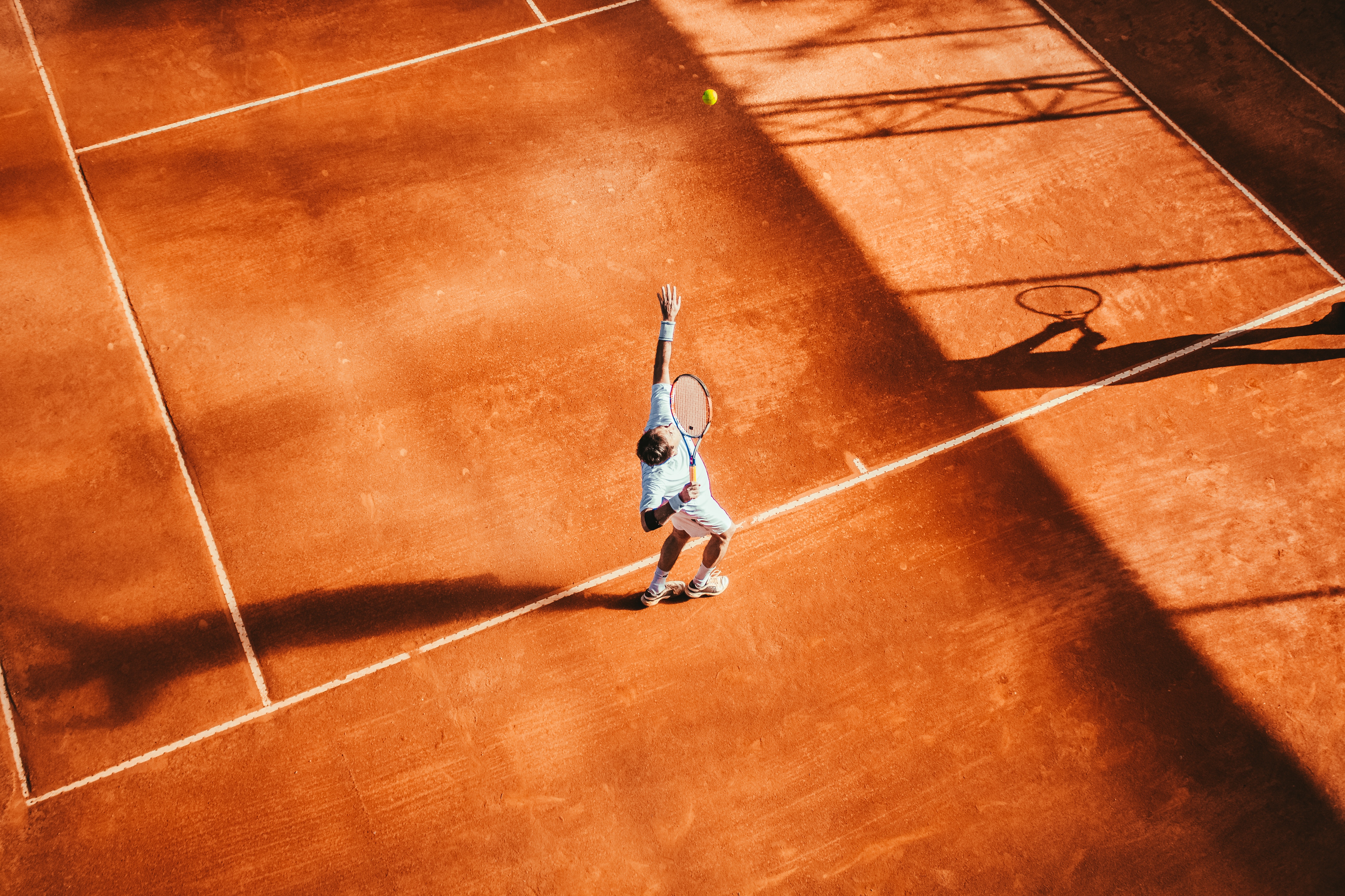 A tennis player throwing a ball in the air