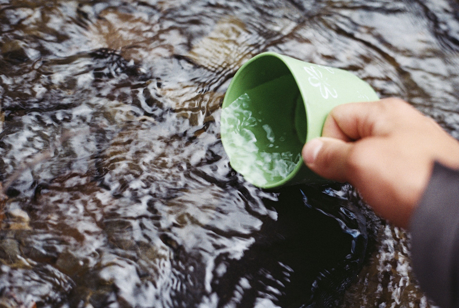 Dipping a cup into a body of water.