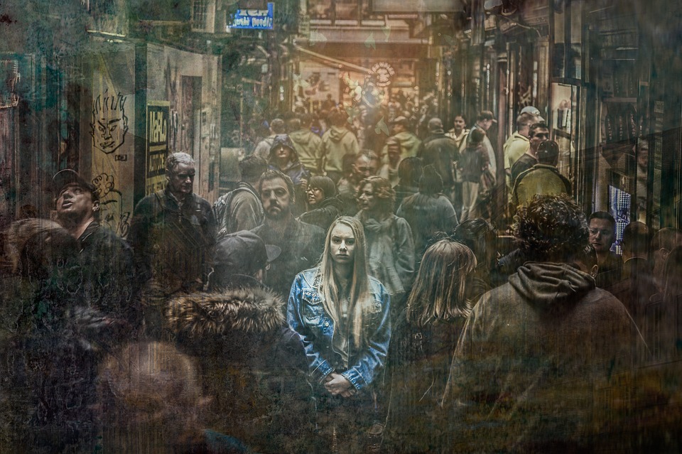 A woman stands in a washed-out, ghostly crowd.