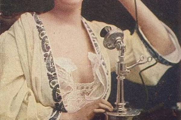 Woman using telephone, c. 1910.