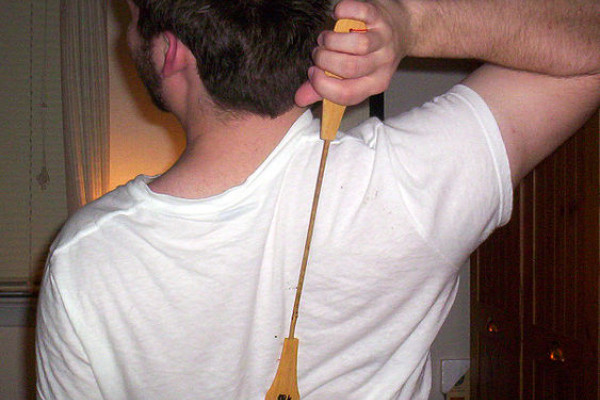 Man scratching back with a Backscratcher