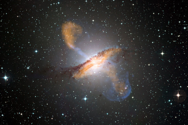 This composite of visible, microwave (orange) and X-ray (blue) data reveals the jets and radio-emitting lobes emanating from Centaurus A's central black hole.