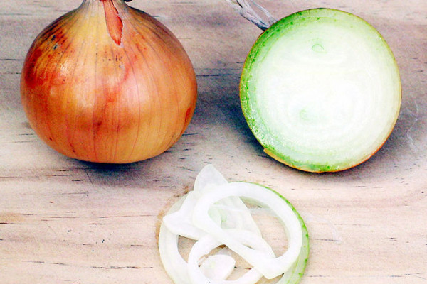 One whole and one cut onion (showing onion rings).