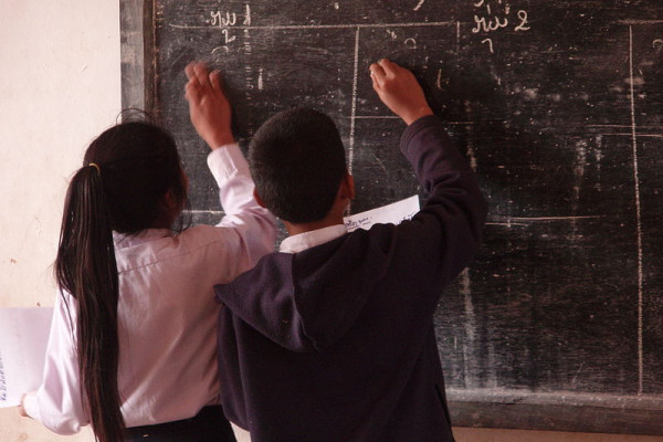 Schoolchildren writing on a blackboard