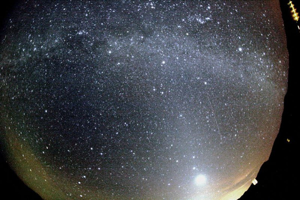 Orionid meteor striking the sky below Milky Way and to the right of Venus. Zodiacal light is also seen at the image. The trail of the meteor appears slightly curved due to edge distortion in the lens.