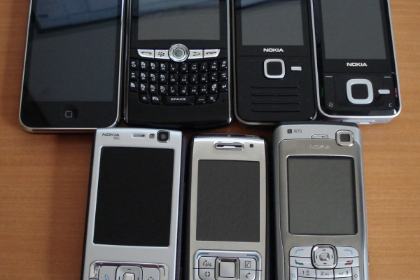 Assorted smartphones. From left to right, top row: iPhone 3G, Blackberry 8820, Nokia N78, Nokia N81, (bottom row) Nokia N95, Nokia E65, Nokia N70.