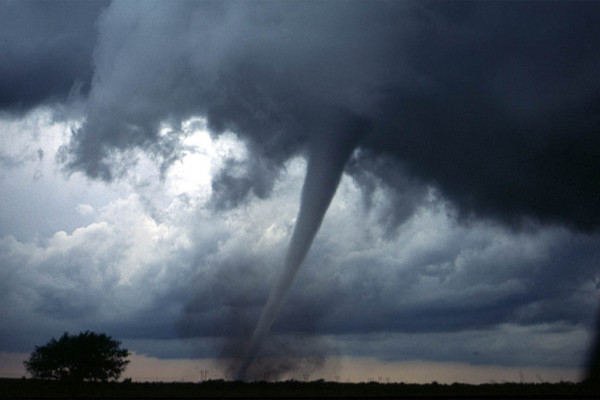 One of several tornadoes observed by the VORTEX-99 team on May 3, 1999, in central Oklahoma. Note the tube-like condensation funnel, attached to the rotating cloud base, surrounded by a translucent dust cloud.