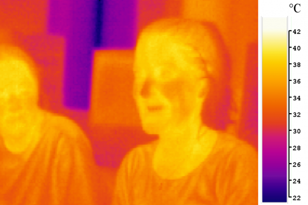 An image of two people in mid-infrared (\thermal\) light (false-color)
