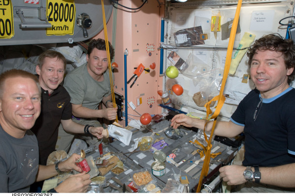  NASA astronaut Tim Kopra (left), European Space Agency astronaut Frank De Winne, cosmonaut Roman Romanenko and NASA astronaut Michael Barratt, all Expedition 20 flight engineers, share a meal at a galley in the Unity node of the International Space...