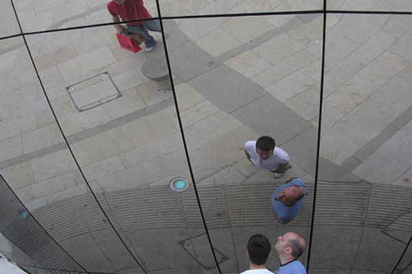 Spherical mirror in Millennium Square, Bristol, England. The photographer is seen top right in the blue shirt. The mirror forms the side of the Explore-At-Bristol Planetarium sphere.