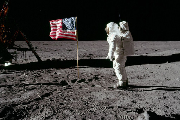 Astronaut Buzz Aldrin poses for a photograph beside the United States flag
