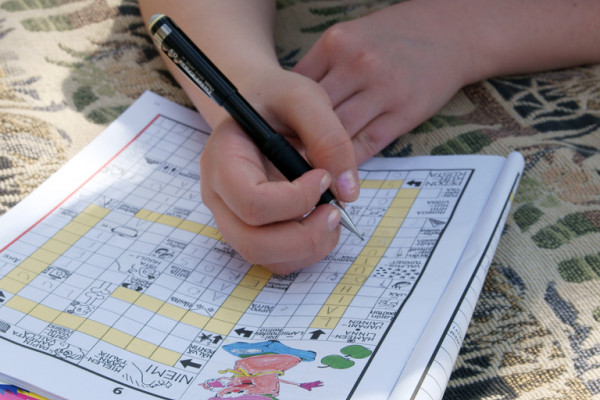 Person solving Finnish crossword puzzle