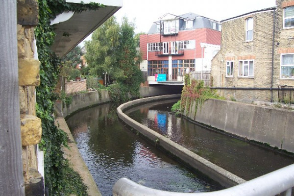 River Wandle, Strathville Rd, SW18. From a road bridge, with some new flats built over the river.