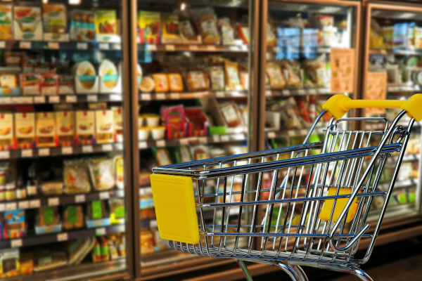 A supermarket trolley in front of freezers