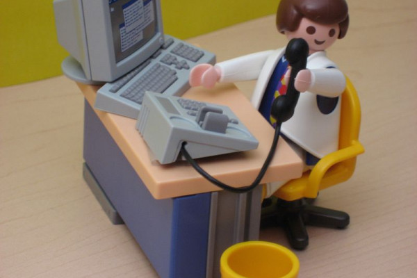 A Playmobil man sitting at a desk