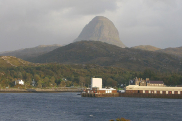  Suilven Caisteal Liath above Lochinver. The 'sugar loaf' Caisteal Liath buttress of Suilven dominates the skyline above Lochinver. This view over the fishing port was taken from the Baddidarach side of Loch Inver. The ornate building by the harbour...