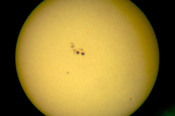  Ocular projection of the sun with large sunspots using a spotting scope (50mm diameter, 45x magnification) and a sheet of paper approx. 30 cm from the ocular. The apparent granulation is due to that of the paper rather than the photospheric...