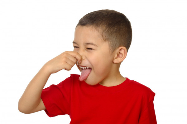 Kid smelling something bad and holding his nose