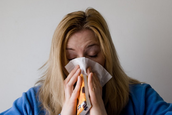 A woman blowing her nose