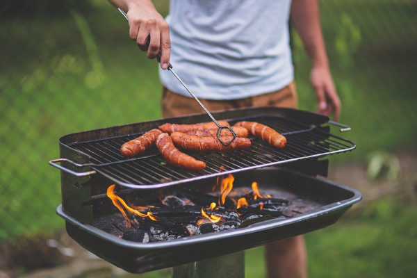 photo of a man cooking meat on a bbq