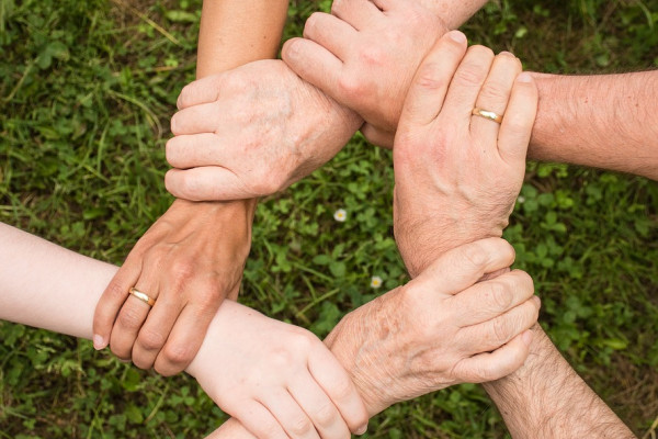 Circle of hands holding each other by the wrist