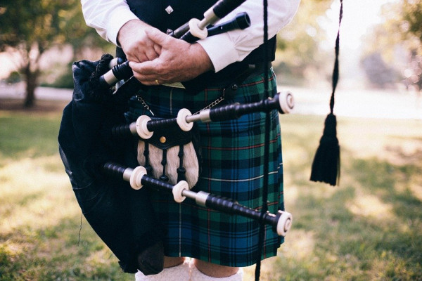 A set of bagpipes held near a kilt.